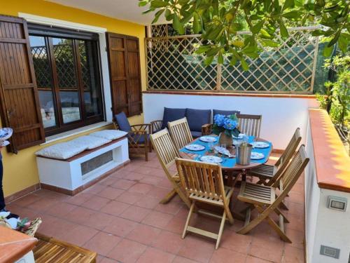 a patio with a table and chairs and a bench at Villino Le Ortensie in Stintino