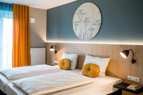a hotel room with a bed with two orange pillows at KONCEPT HOTEL Neue Horizonte in Tübingen