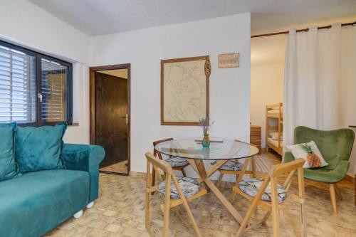 a living room with a blue couch and a glass table at Casa al mare in Sveti Juraj