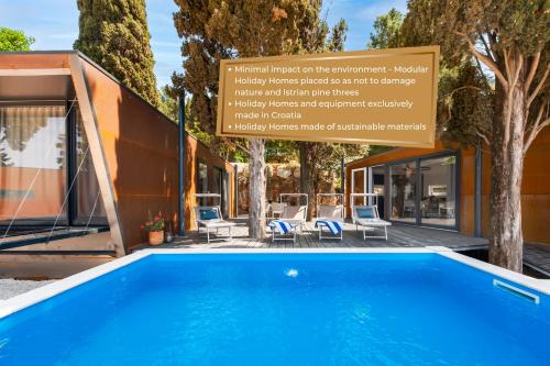 a swimming pool in front of a house with a sign at Porton Nature Hideouts in Rovinj