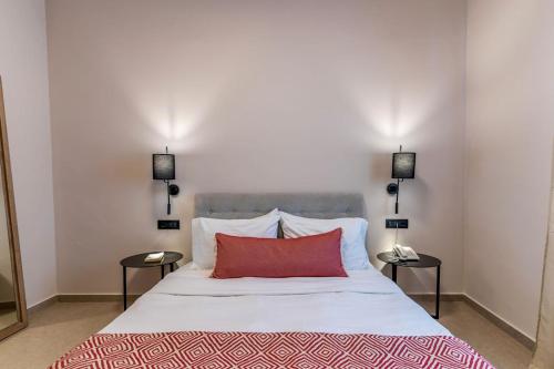 a bedroom with a large white bed with a red pillow at Hotel Eucalyptus in Mesaria