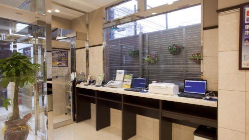 a lobby with two laptop computers on a counter at Toyoko Inn Kyoto Biwako Otsu in Otsu