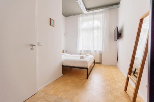 a white room with a bed and a window at Green Residence Boutique Lofts & Villa am Park in Offenbach