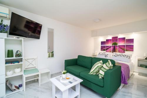 - un salon avec un canapé vert et un lit dans l'établissement Apartment Laneta, à Dubrovnik