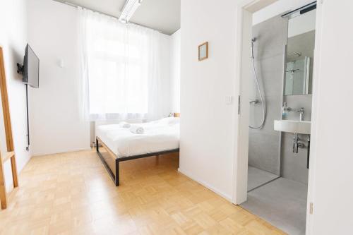 a bathroom with a bed and a shower and a sink at Green Residence Boutique Lofts & Villa am Park in Offenbach