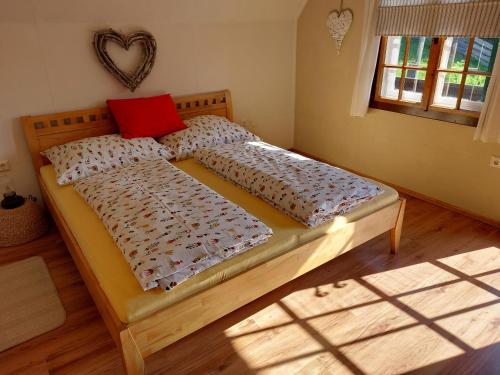 Una cama en un dormitorio con una almohada roja. en Knusperhaus Ogris, en Trieblach