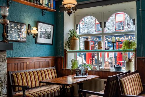 a restaurant with a table and chairs and a window at Foley's Guesthouse & Self Catering Holiday Homes in Kenmare