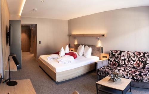 a hotel room with a bed and a couch at Hotel Post in Prutz
