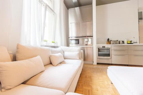 a white living room with a white couch and a kitchen at Green Residence Boutique Lofts & Villa am Park in Offenbach