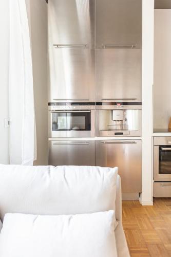 a kitchen with stainless steel appliances and a white couch at Green Residence Boutique Lofts & Villa am Park in Offenbach
