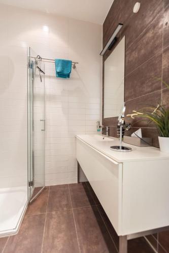 a bathroom with a sink and a shower at Green Residence Boutique Lofts & Villa am Park in Offenbach