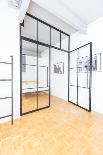 an empty room with glass doors and a wooden floor at Green Residence Boutique Lofts & Villa am Park in Offenbach