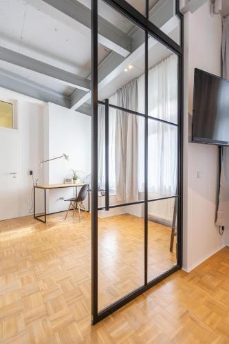 a room with a sliding glass door and a desk at Green Residence Boutique Lofts & Villa am Park in Offenbach