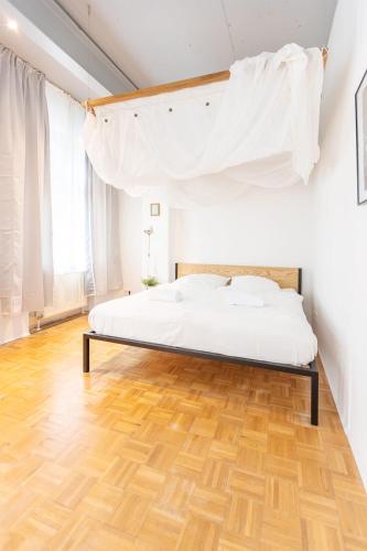 a bedroom with a bed and a wooden floor at Green Residence Boutique Lofts & Villa am Park in Offenbach