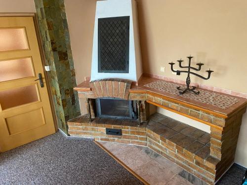 a brick fireplace in a room next to a door at Chata Čeladná in Čeladná