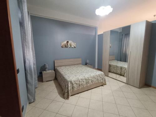 Schlafzimmer mit einem Bett und einem Spiegel in der Unterkunft Casa vacanze Veronica in Campi Salentina