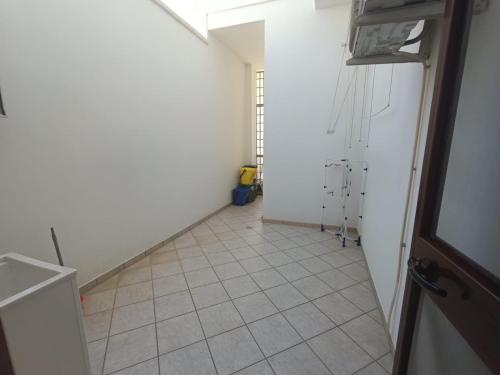 corridoio con pavimento piastrellato e camera bianca. di Casa vacanze Veronica a Campi Salentina