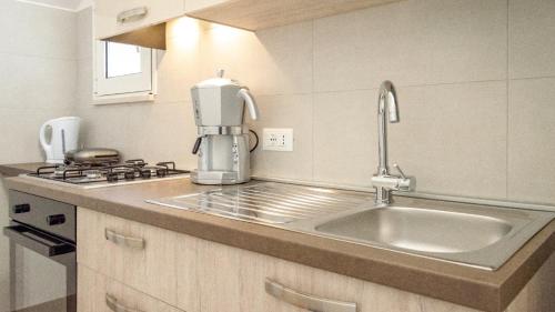 a kitchen with a sink and a mixer on a counter at Casetta La Conchiglia in Villanova di Ostuni