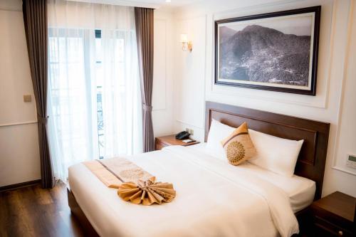 a hotel room with a bed with a bow on it at Camellia Luxury Hotel Tam Đảo in Tam Ðảo