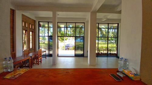 a living room with a table and some glass doors at MIN Guest House Watukarung in Pacitan