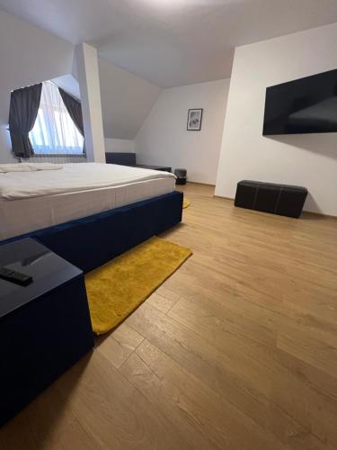 1 dormitorio con 1 cama y suelo de madera en Casa Mignon, en Oradea