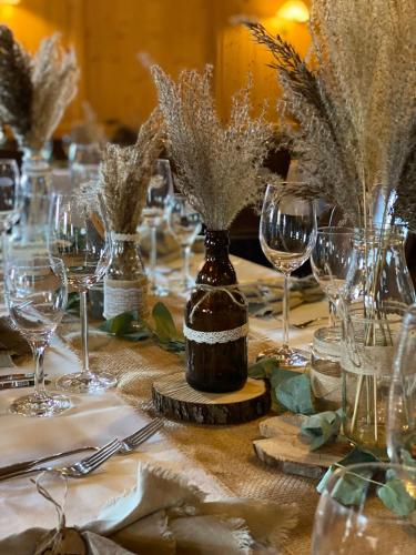 a table with glasses and vases with flowers on it at AllgäuStern Hotel in Sonthofen