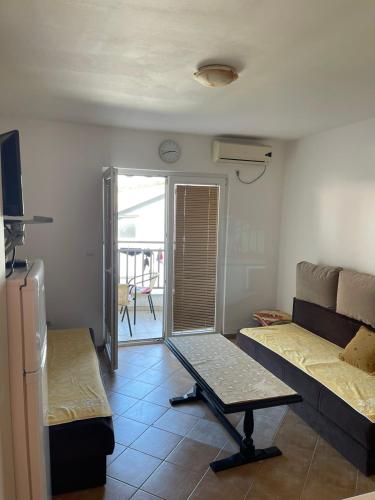 ein Wohnzimmer mit einer Couch und einem Tisch darin in der Unterkunft apartman "Sutorina" in Igalo