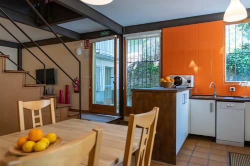 a kitchen with a table with a bowl of fruit on it at Casa La Vera Rural in Talaveruela