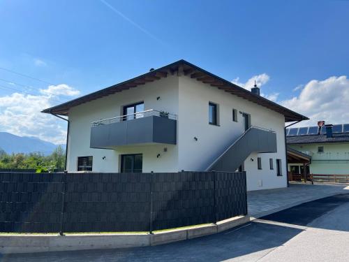 a white house with a fence in front of it at Ferienwohnung Ott in Ebbs