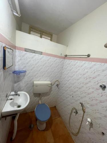 a bathroom with a toilet and a sink at Imperial Inn - HAROZ in Kuttālam