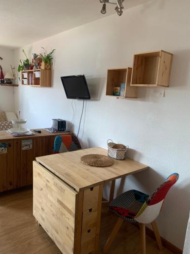 une cuisine avec une table en bois et une chaise dans l'établissement APPARTEMENT COSY ET ENSOLEILLÉ REBERTY 2000 VUE MONTAGNE, à Levassaix