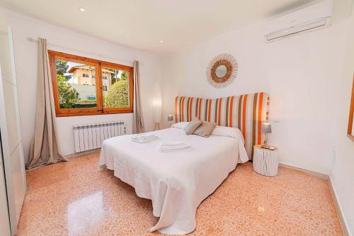 Un dormitorio con una cama blanca y una ventana. en Can Mir Ruth by Sealand Villas, en Puerto Pollensa