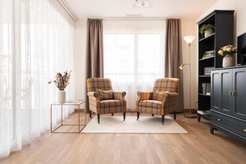 a living room with two chairs and a window at Senevita Ahornpark in Bätterkinden