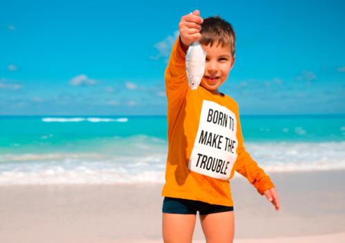 a young boy holding up a toy on the beach at Retal View North Coast Aqua Park in El Alamein