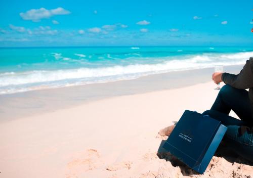 a person sitting on the beach with a blue bag at Retal View North Coast Aqua Park in El Alamein