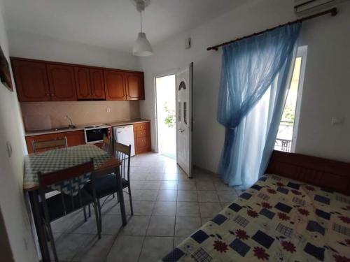 a kitchen with a table and a dining room at Basilis room in Loutsa