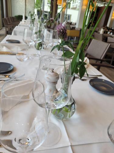 a table with glasses and a vase with flowers in it at Senevita Ahornpark in Bätterkinden