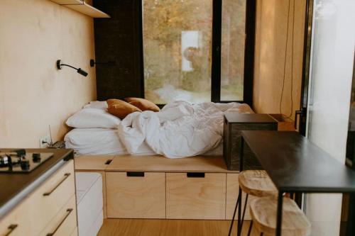 ein Bett auf einem Tisch in einem kleinen Zimmer in der Unterkunft Parcel Tiny House I Le P'tit Clos Normand 