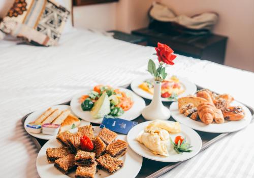 a tray with four plates of food on a bed at Retal View North Coast Aqua Park in El Alamein