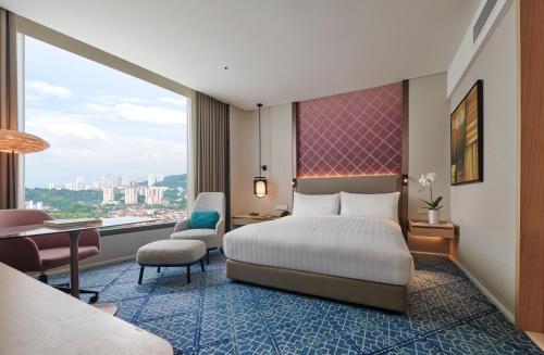 una camera d'albergo con letto, scrivania e tavolo di Amari SPICE Penang a Bayan Lepas