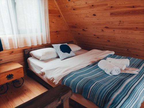 a bed in a log cabin with two pillows on it at Çınarhan Villas in Agva