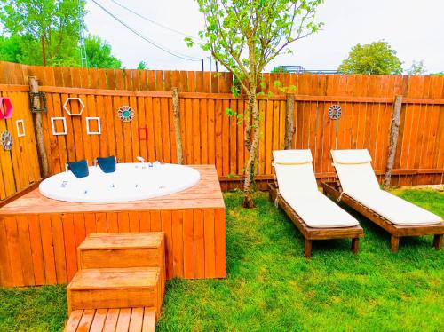 a backyard with a sink and two chairs and a wooden fence at Çınarhan Villas in Agva