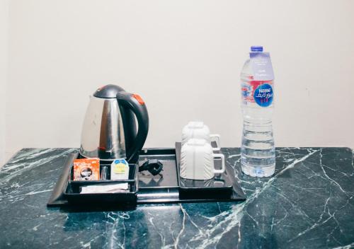 a coffee maker and a bottle of water on a counter at Retal View North Coast Aqua Park in El Alamein