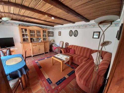 ein Wohnzimmer mit einem Sofa und einem Tisch in der Unterkunft Ferienhäuschen Rosi Brehm in Hollfeld