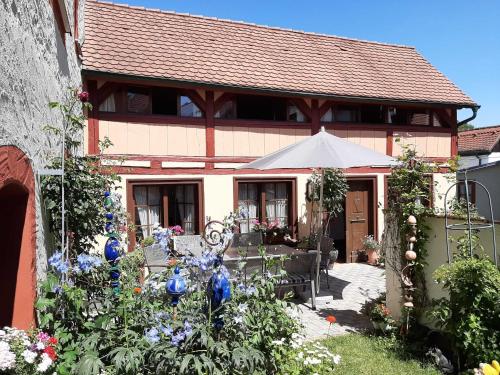 ein Haus mit einem Garten mit Blumen und blauen Vasen in der Unterkunft Ferienhäuschen Rosi Brehm in Hollfeld