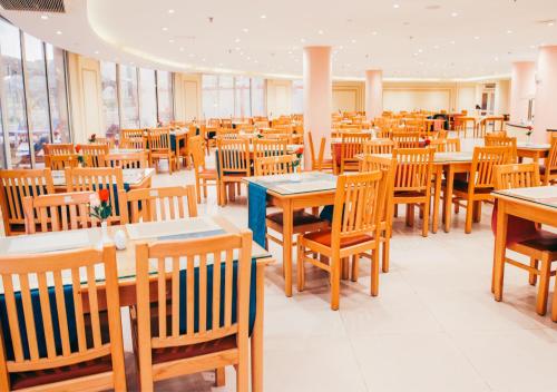 a dining room filled with tables and wooden chairs at Retal View North Coast Aqua Park in El Alamein