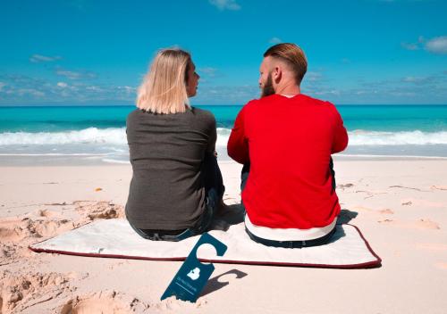 a man and a woman sitting on the beach at Retal View North Coast Aqua Park in El Alamein