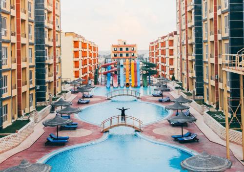 a large swimming pool in a city with buildings at Retal View North Coast Aqua Park in El Alamein