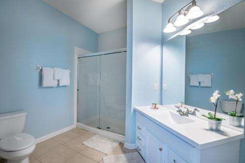 a bathroom with a toilet and a sink and a mirror at Gorgeous Top-Floor Condo w Private Balcony in Orlando