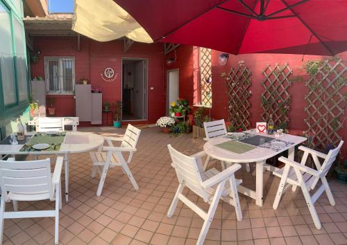 un patio con due tavoli, sedie e ombrellone di Starnone Bed&Book a Napoli